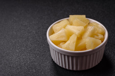 Tropical sweet pineapple fruit sliced into slices. Pineapple as an ingredient for pizza or saladの写真素材