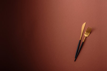Knife and fork, cutlery on a brown dining table. Utensils and crockery for preparing dinnerの写真素材