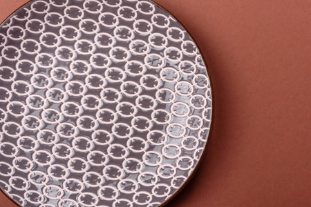 Empty ceramic plate on a monochrome brown background. Empty plate with cutlery on a dining tableの写真素材