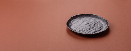 Empty plate on a monochrome brown background.の写真素材