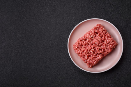 Stuffing or ground raw beef or pork with salt and spices on a black backgroundの写真素材