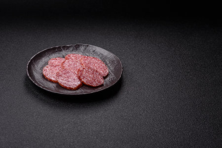 Sliced salami sausage, smoked meat, delicious deli snacks on a plateの写真素材