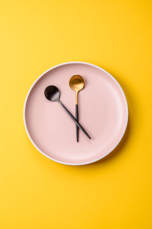 Empty plate with devices in the form of clock hands as a conceptual background for lunch time, coffee break, mealの写真素材
