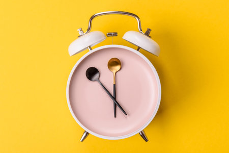 Empty plate with devices in the form of clock hands as a conceptual background for lunch time, coffee break, mealの写真素材