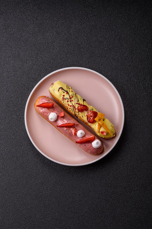 French food, dessert eclair with chocolate filling and covered with colored icing. Sweet eclair as a...
