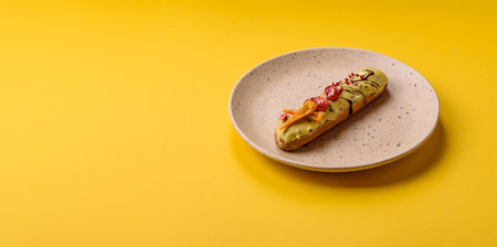 French food, dessert eclair with chocolate filling and covered with colored icing. Sweet eclair as a background for your designの写真素材