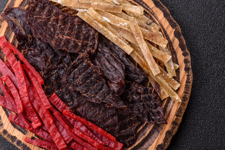 A set of jerky or snacks of beef, chicken and fish with salt and spices.の写真素材