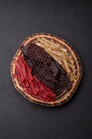A set of jerky or snacks of beef, chicken and fish with salt and spices.の写真素材