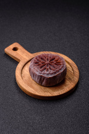 Chinese mooncake is an Asian sweet dessert with a coating of rice dough and fruit filling. Asian...