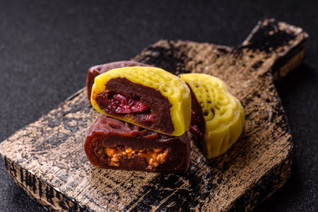 Chinese mooncake is an Asian sweet dessert with a coating of rice dough and fruit filling. Asian mooncake as a background for your designの写真素材