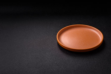 Empty round black plate for food, kitchen utensils on dining table. Empty plate on dark backgroundの写真素材