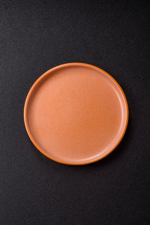 Empty round black plate for food, kitchen utensils on dining table. Empty plate on dark backgroundの写真素材