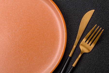 Empty round black plate for food, kitchen utensils on dining table. Empty plate on dark backgroundの写真素材