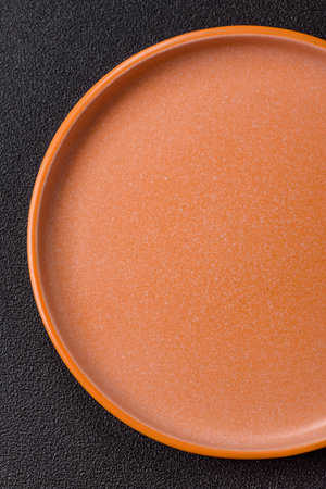 Empty round black plate for food, kitchen utensils on dining table. Empty plate on dark backgroundの写真素材