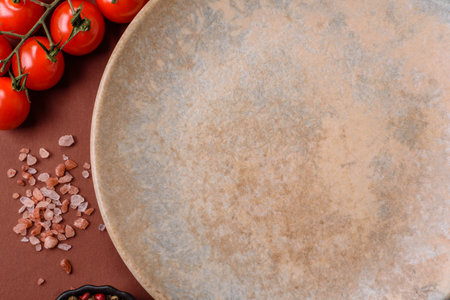Empty round black plate for food, kitchen utensils on dining table. Empty plate on dark backgroundの写真素材