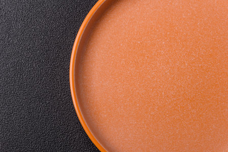 Empty round black plate for food, kitchen utensils on dining table. Empty plate on dark backgroundの写真素材