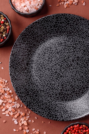 Empty round black plate for food, kitchen utensils on dining table. Empty plate on dark backgroundの写真素材