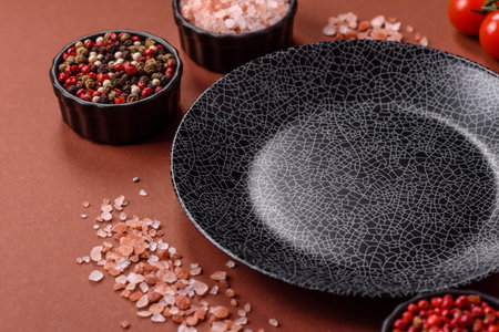 Empty round black plate for food, kitchen utensils on dining table. Empty plate on dark backgroundの写真素材