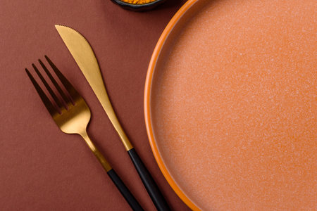 Empty round black plate for food, kitchen utensils on dining table. Empty plate on dark backgroundの写真素材