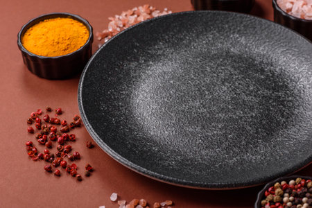 Empty round black plate for food, kitchen utensils on dining table. Empty plate on dark backgroundの写真素材