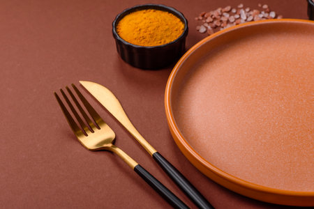 Empty round black plate for food, kitchen utensils on dining table. Empty plate on dark backgroundの写真素材