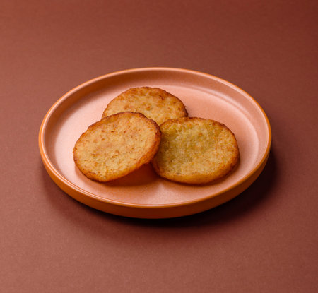 Hash browns, a breakfast food made of potatoes, onions and vegetables. Hash browns with potatoes, salt and spices on a dark concrete backgroundの写真素材
