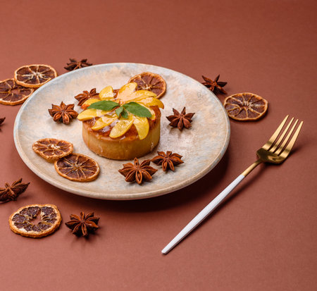 Sweet round pie or tart with apples and peach, cream and nuts. Mini sweet tart with fruit slicesの写真素材