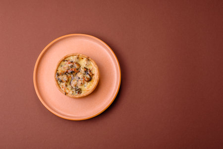 Pie or quiche, a sour tart with chicken and mushrooms, spices and herbs on a dark concrete...