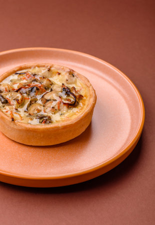 Pie or quiche, a sour tart with chicken and mushrooms, spices and herbs on a dark concrete background. Round quiche with chickenの写真素材