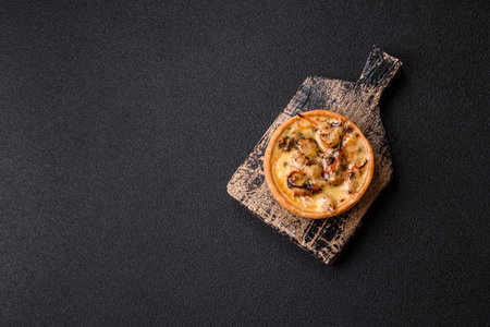 Pie or quiche, a sour tart with chicken and mushrooms, spices and herbs on a dark concrete background. Round quiche with chickenの写真素材