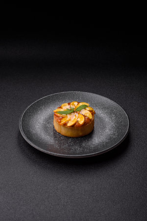 Sweet round pie or tart with apples and peach, cream and nuts. Mini sweet tart with fruit slicesの写真素材