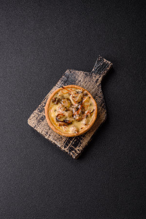 Pie or quiche, a sour tart with chicken and mushrooms, spices and herbs on a dark concrete background. Round quiche with chickenの写真素材