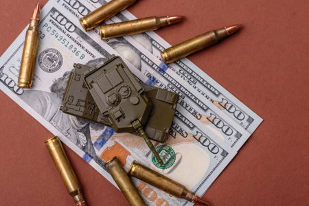 Money, cash dollars to fund weapons for war and defense against attack. Dollars for war as a conceptual backdropの写真素材