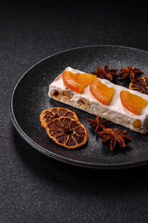 Nougat or white caramel with hazelnuts and pistachios and citrus pieces. White nougat with nuts, sweets for the festive tableの写真素材