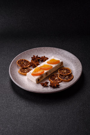 Nougat or white caramel with hazelnuts and pistachios and citrus pieces. White nougat with nuts, sweets for the festive tableの写真素材