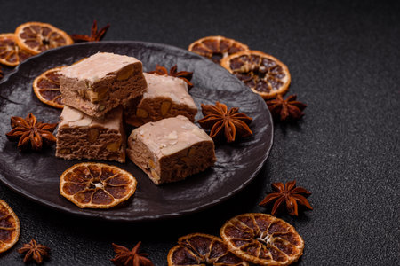 Nougat or white caramel with hazelnuts and pistachios and citrus pieces. White nougat with nuts, sweets for the festive tableの写真素材