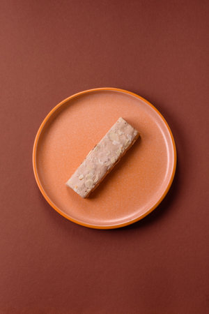 Nougat or white caramel with hazelnuts and pistachios and citrus pieces. White nougat with nuts, sweets for the festive tableの写真素材