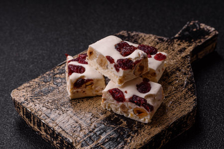 Nougat or white caramel with hazelnuts and pistachios and citrus pieces. White nougat with nuts, sweets for the festive tableの写真素材