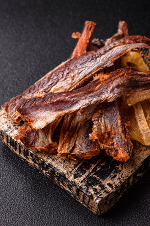 Dried salted fish as snacks or jerky, seafood as slices. Dried seafood snacks as a background for...