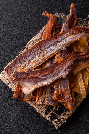 Dried salted fish as snacks or jerky, seafood as slices. Dried seafood snacks as a background for...