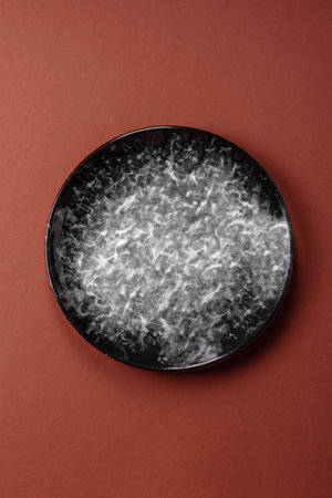 Empty round black plate for food, kitchen utensils on dining table. Empty plate on dark backgroundの写真素材