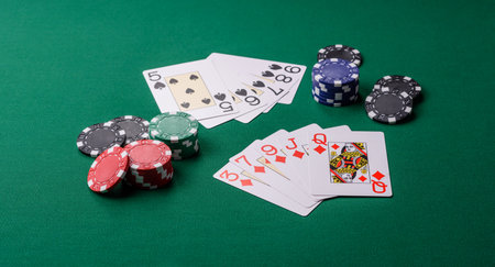 Playing card game poker in casino with chips, bets and risk. Cards and chips on green felt as...