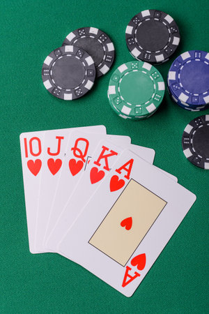 Playing card game poker in casino with chips, bets and risk. Cards and chips on green felt as...