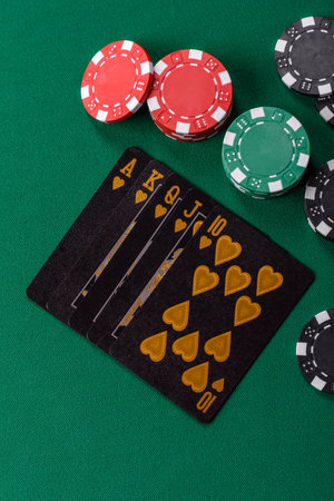 Playing card game poker with chips, bets and risk. Cards and chips on green felt as background for...