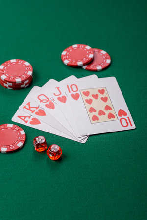 Playing card game poker in casino with chips, bets and risk. Cards and chips on green felt as...