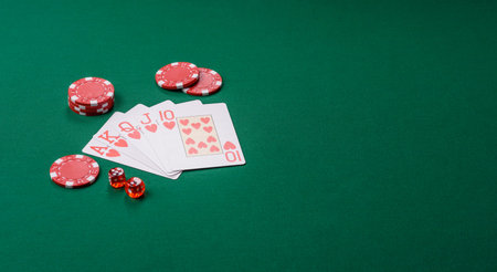 Playing card game poker in casino with chips, bets and risk. Cards and chips on green felt as...