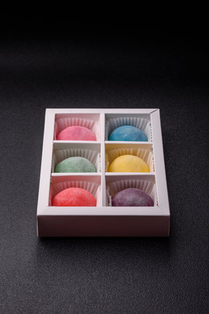 Japanese mochi, ice cream or Asian sweets made from rice flour with fruit filling. Mochi of different colors with fruit filling as food backgroundの写真素材