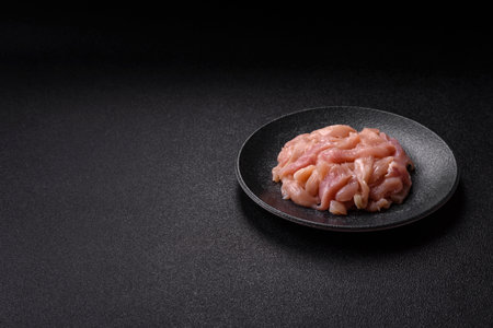 Raw chicken meat cut into strips, fresh fillet or breast slices. Chicken raw meat in pieces as a...