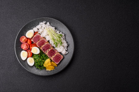 Seafood bowl, tuna tataki fillet slices with rice, oranges, tomatoes and sauce. Tuna bowl as a food background for your designの写真素材
