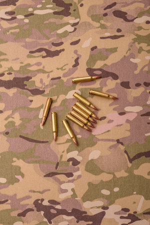 Machine gun cartridges on a camouflage background, military wallpaper. Camouflage background as a backdrop for your designの写真素材